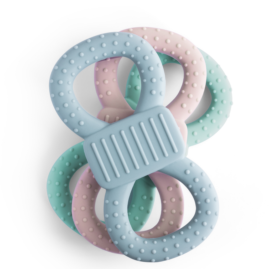 Drei gestapelte Silikon-Beißringe, wobei der hellblaue Ring oben liegt und die genoppte Struktur zeigt.